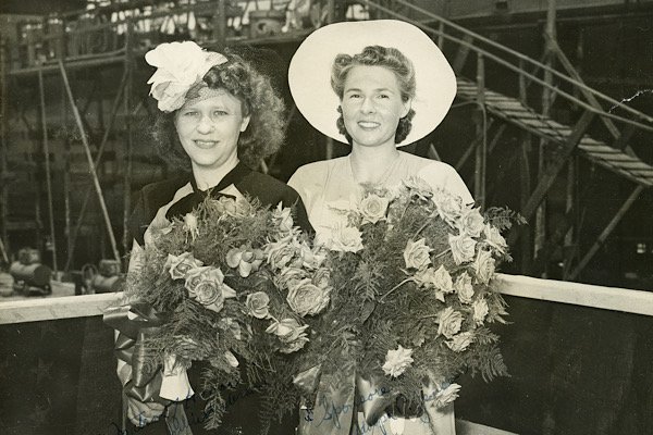 Mrs. Lucille Jensen (right) in her role as sponsor at the launch ceremony for USS YO-193 on July 29, 1945. She stands alongside Mrs. Julius Anderson, the co-sponsor and “matron of honor,”  whose husband was the master shipwright at Brunswick Marine.