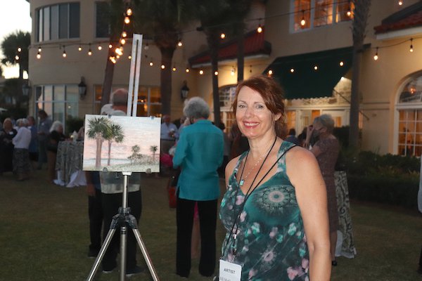 Jill McGannon with her painting of the palm trees at dusk