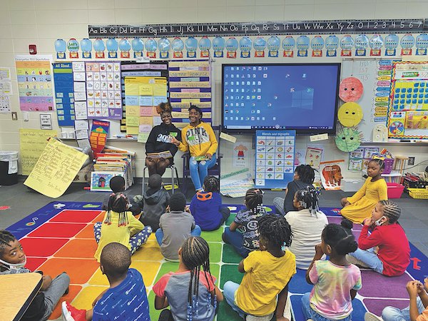 Glynn Academy and CIS senior A'Zaria with her former teacher, Mrs. Chipp-Brown, at Burroughs-Molette Elementary School, reading to Kindergarten students. A'Zaria will graduate in May.