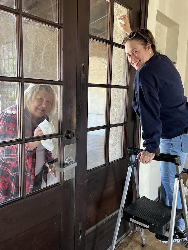 Jennifer Matthewson and Linda Hlozansky of Magnolia Garden Club making the windows sparkle.