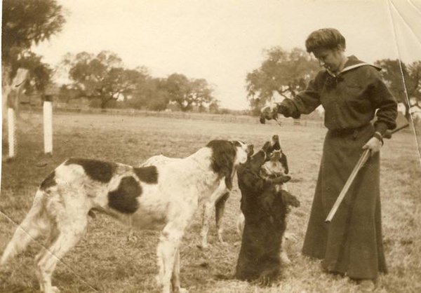 Ophelia Dent with her shotgun, dogs, and rice bird